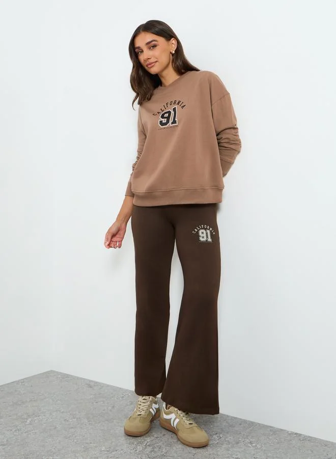 ستايلي طقم منسق من بنطال بأرجل واسعة وسويت شيرت بطبعة كتابة